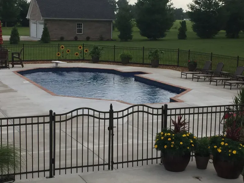 A large swimming pool is behind a metal fence