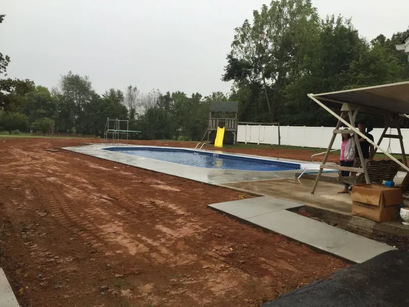 A large swimming pool is being built in a backyard