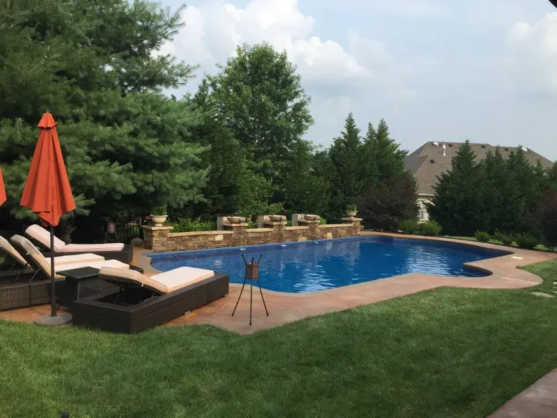 A large swimming pool surrounded by chairs and umbrellas