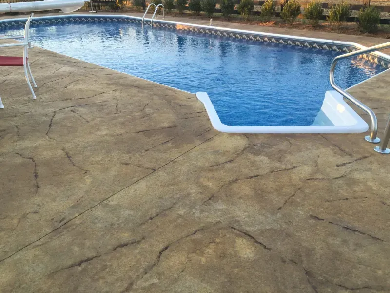A large swimming pool is surrounded by a concrete deck