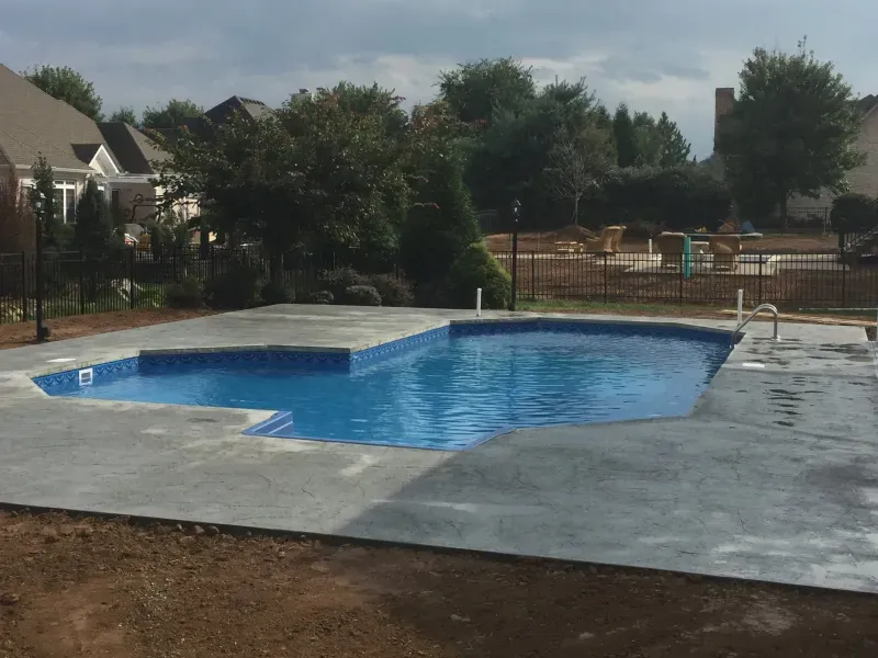 A large swimming pool in the backyard of a house.