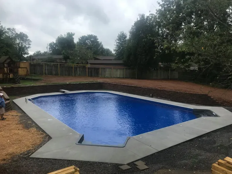 A large swimming pool is being built in a backyard.