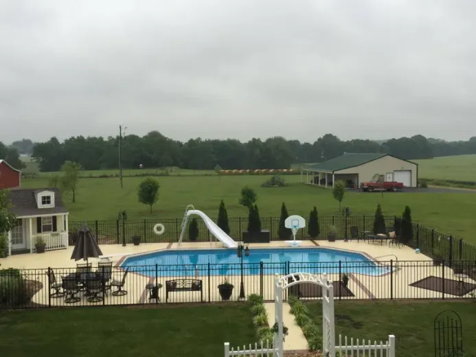 A large swimming pool surrounded by a fence in a backyard.