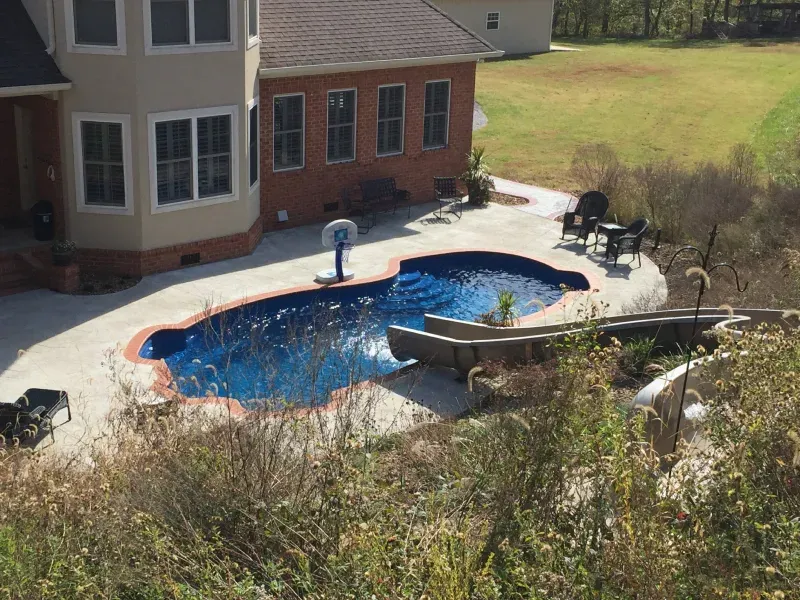 A large house with a large swimming pool in front of it.