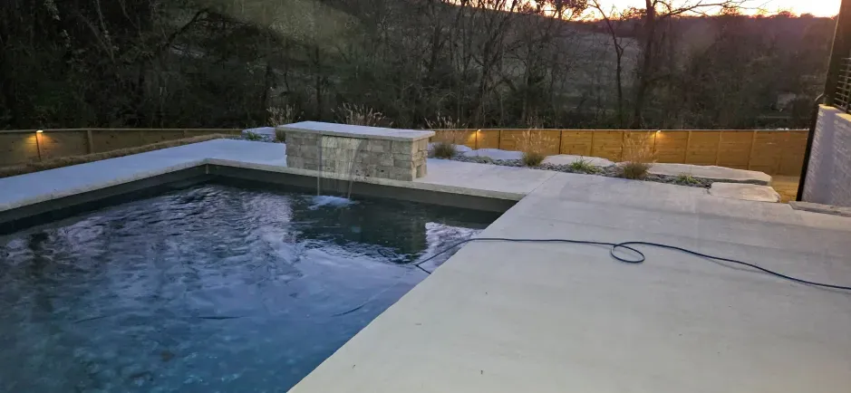 A large swimming pool with a hose attached to the side of it.