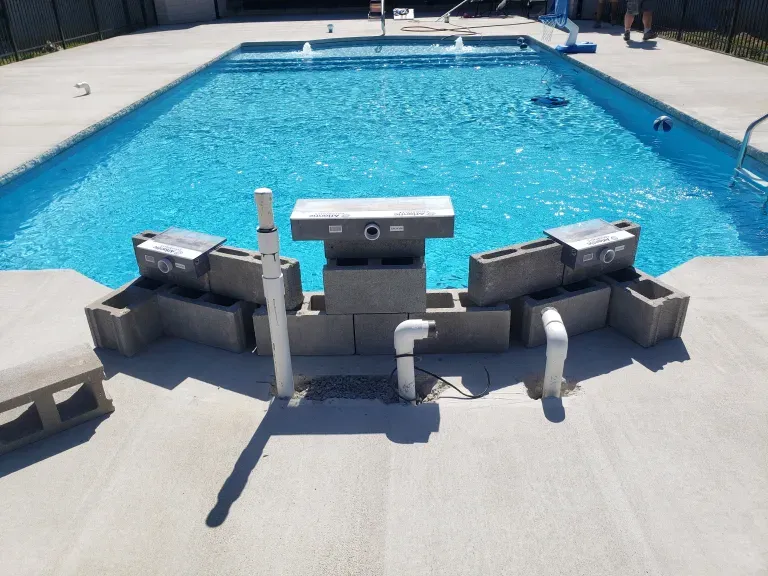 A swimming pool surrounded by concrete blocks and pipes