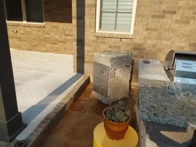 A potted plant sits on a yellow table in front of a brick building