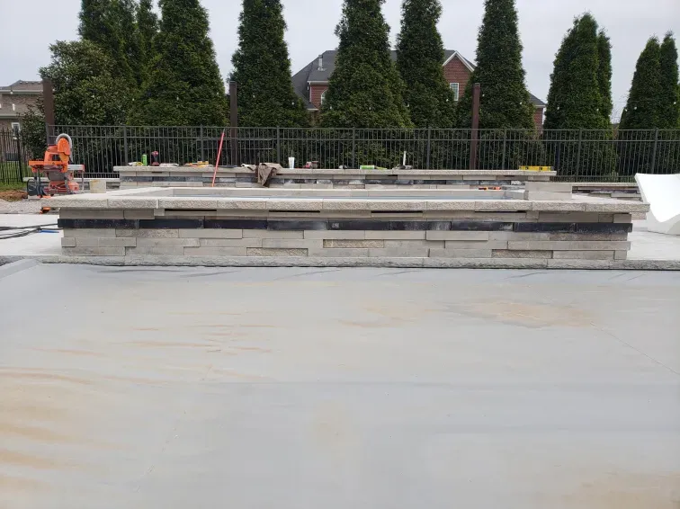 A construction site with a fence and trees in the background
