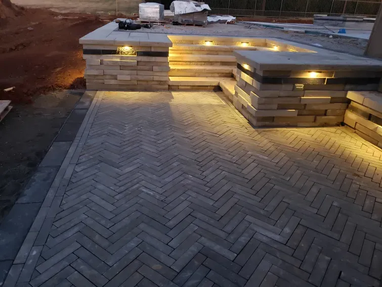 A brick walkway with stairs and lights on it.