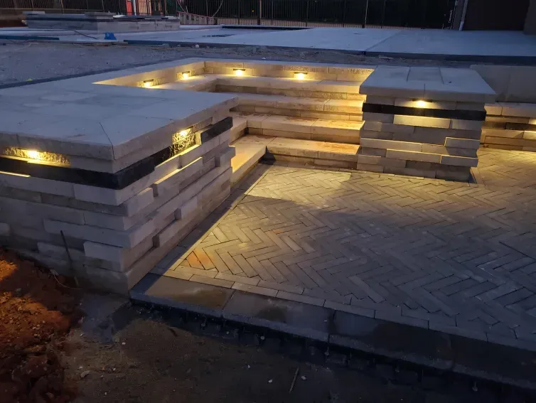A brick walkway with stairs and lights on it