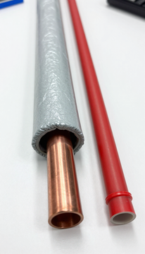 Gray and red insulated electrical wires with exposed copper ends on a white surface
