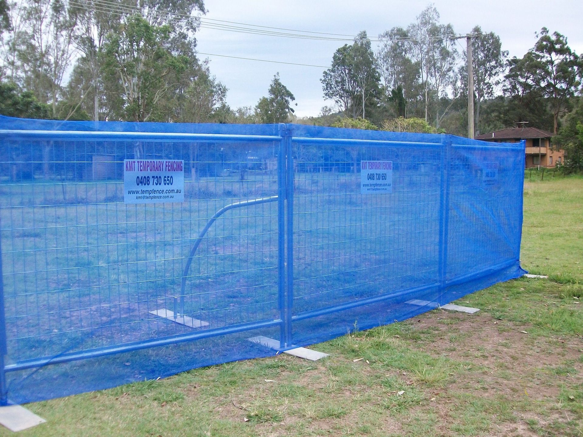 A blue fence with a sign that says ' warning ' on it