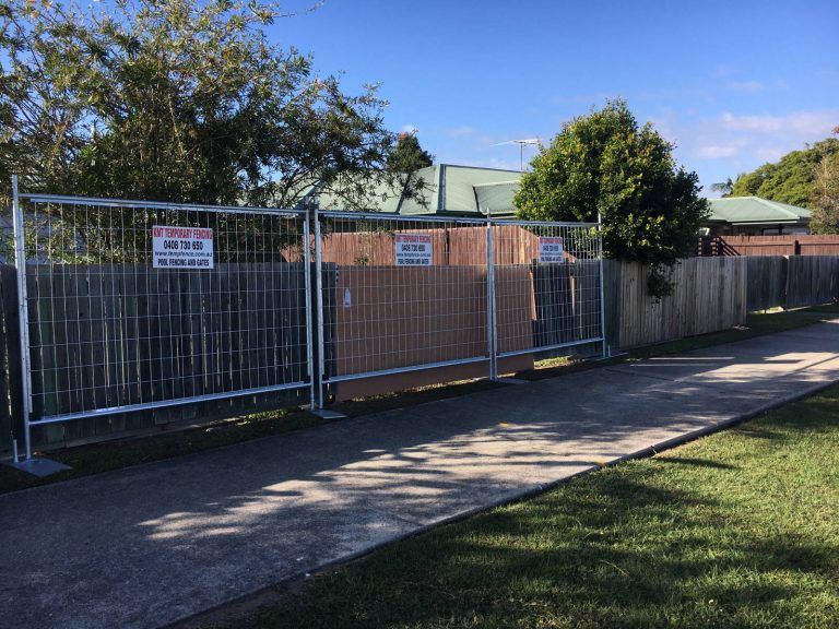 A fence is being built in front of a house.