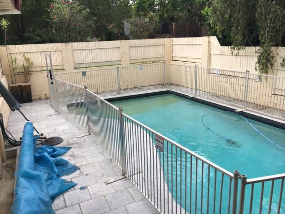 A large swimming pool with a metal fence around it