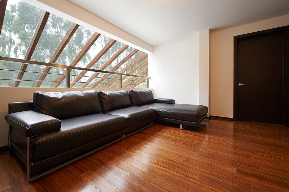 Modern Living Room With a Dark Sectional Sofa — Gatley Building Design in Woodgate, QLD