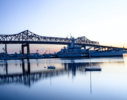 A bridge over a body of water with boats in the water.