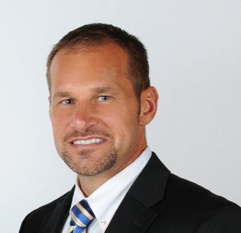 A man in a suit and tie smiles for the camera