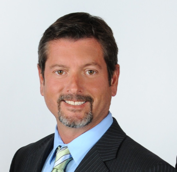 A man in a suit and tie smiles for the camera