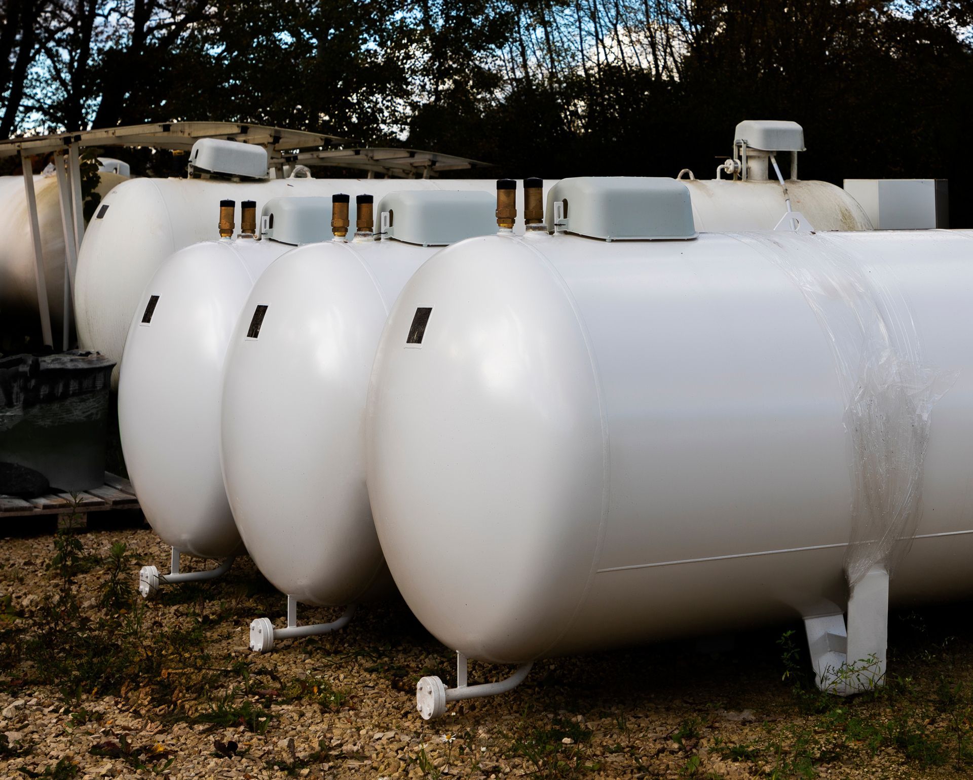 A Row of White Tanks Are Lined up In a Field