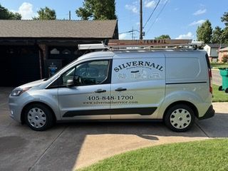 Silver van with ladder on top,