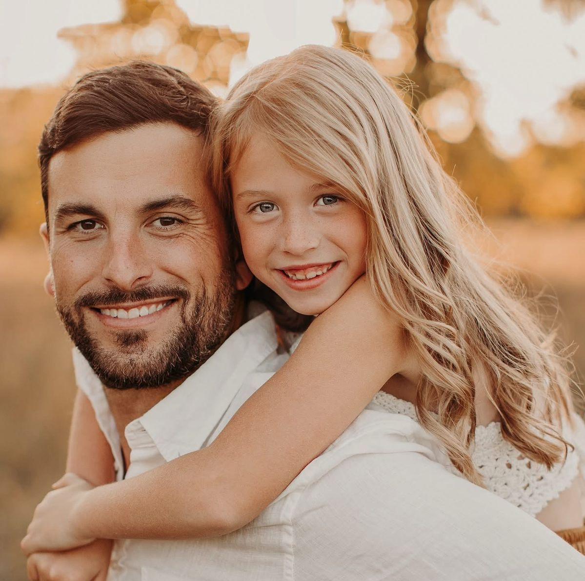 Fire hose valve on a white wall with a red handle and metal body.