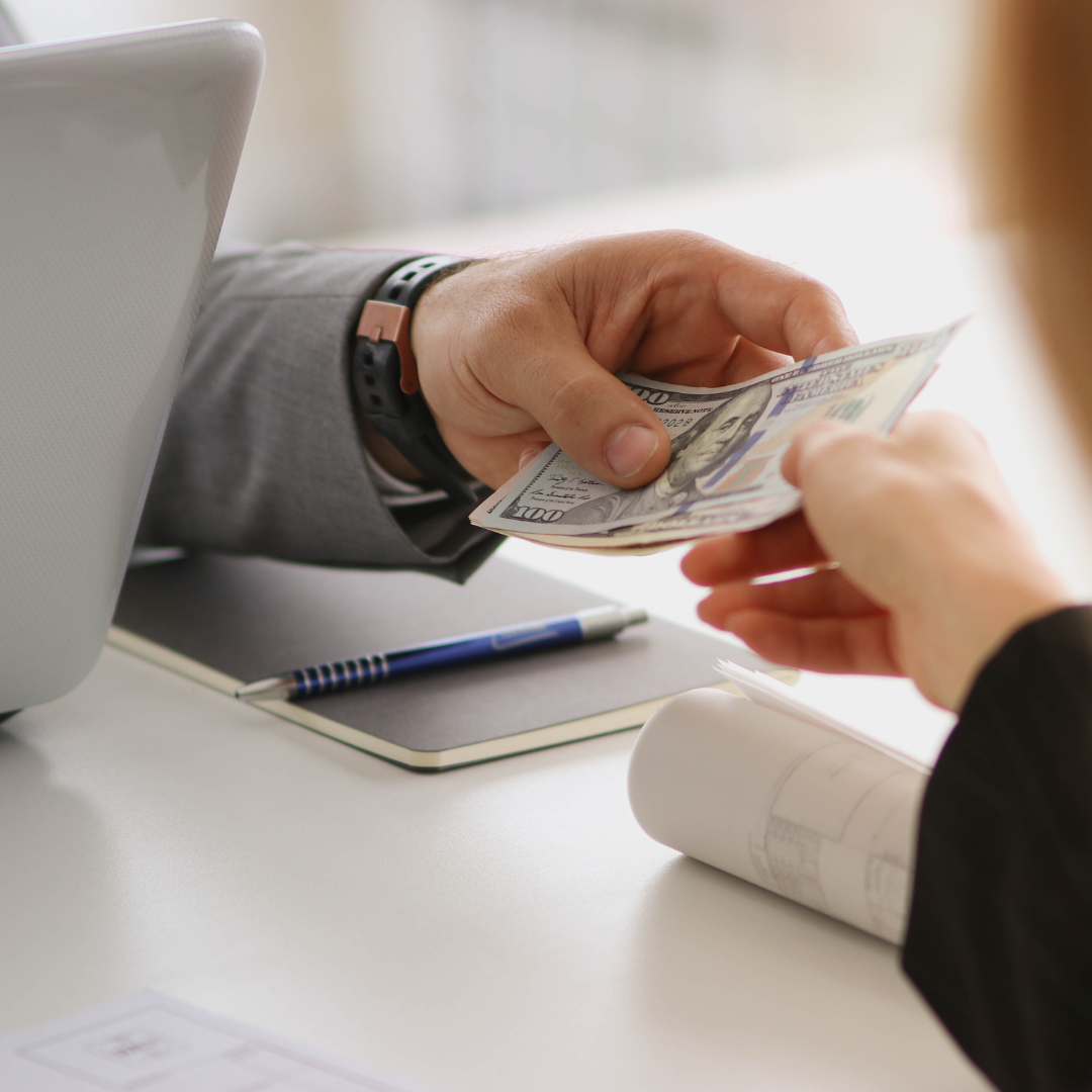 A person is handing a dollar bill to another person