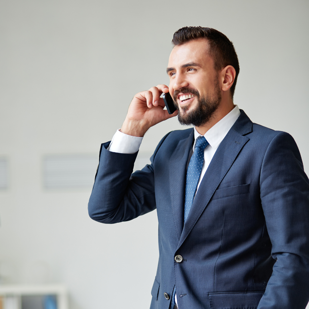 A man in a suit and tie is talking on a cell phone.
