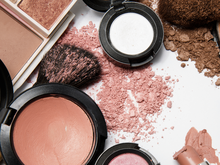 A variety of makeup products are on a white surface