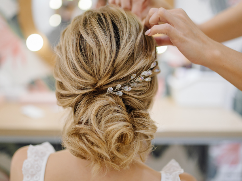 A woman is getting her hair done by a hairdresser in a salon.
