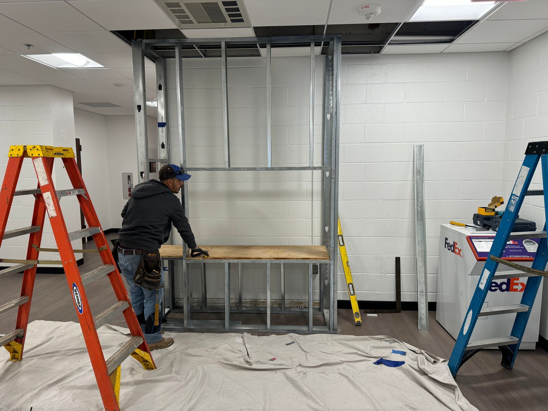 Contractor is standing next to a ladder and working on the project