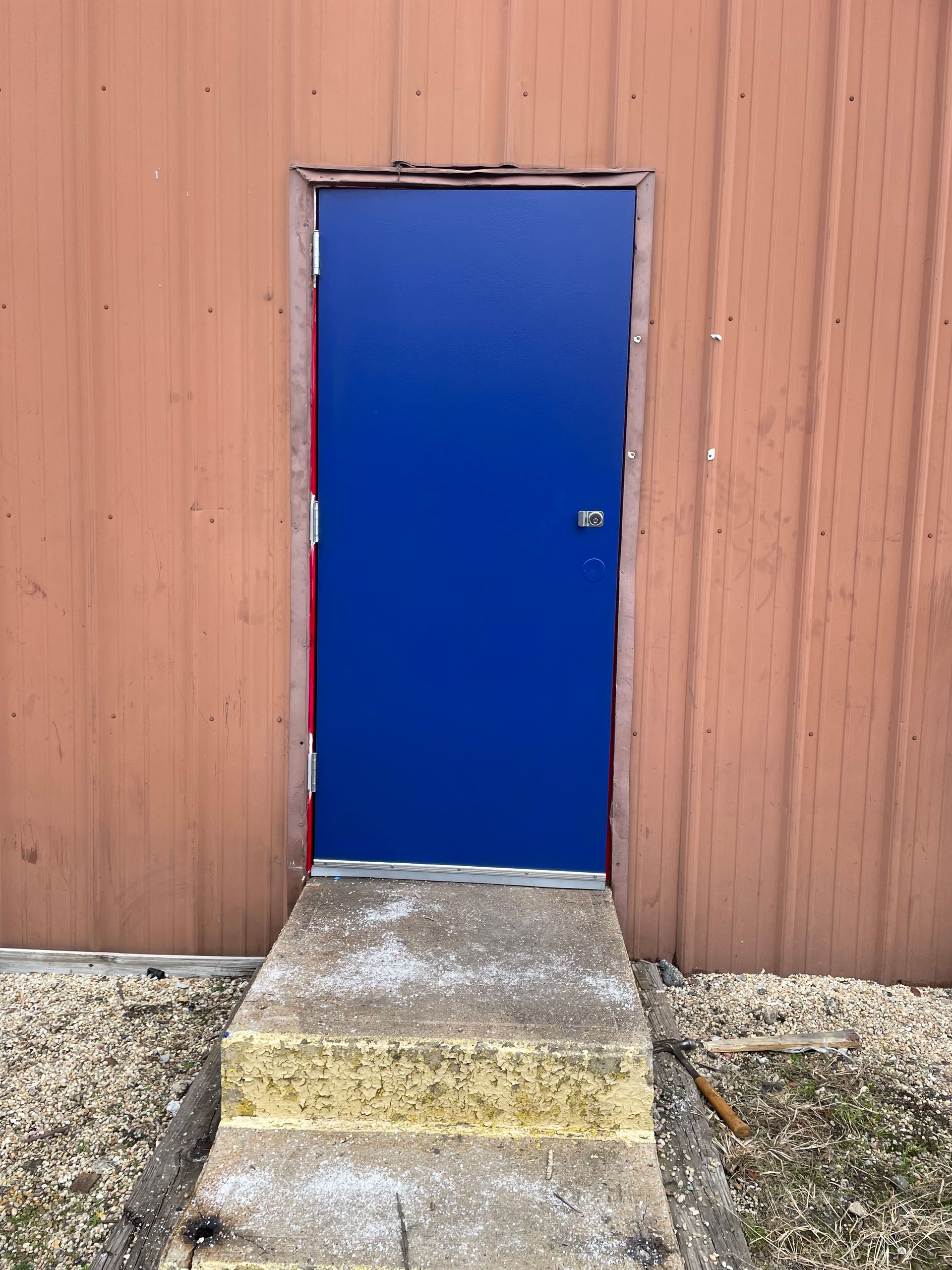 A blue door with steps leading up to it