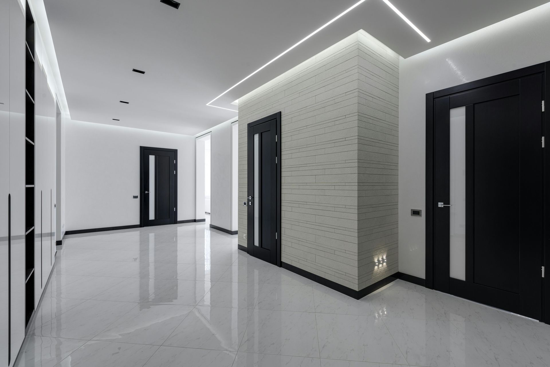 An empty hallway with black doors and white walls
