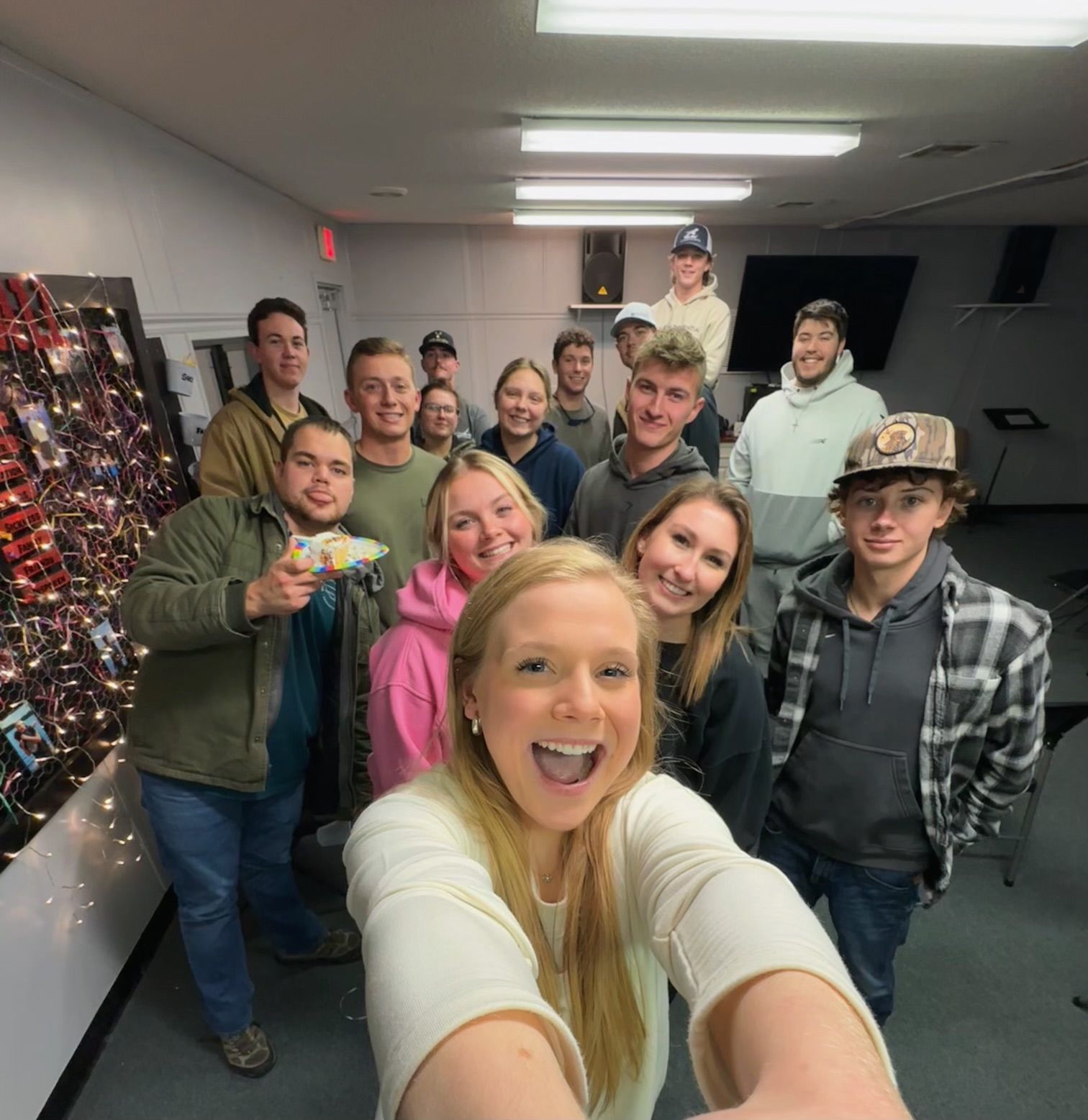 A woman taking a selfie with a group of people