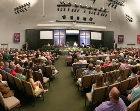 A large group of people are sitting in a church auditorium.