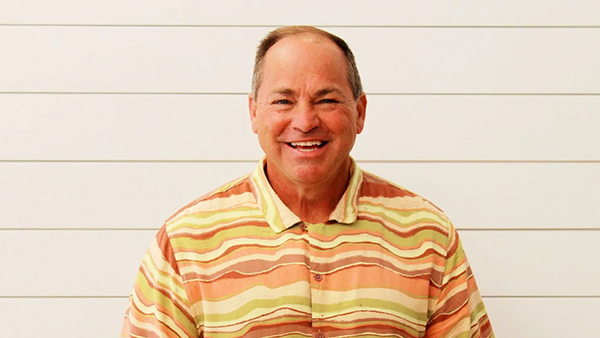 A man in a plaid shirt is smiling for the camera.