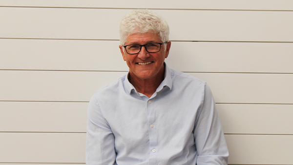 A man in a plaid shirt is smiling for the camera.