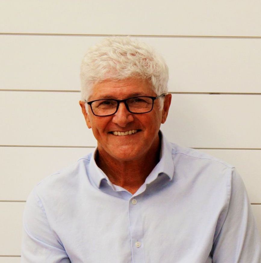 A man in a plaid shirt is smiling for the camera.