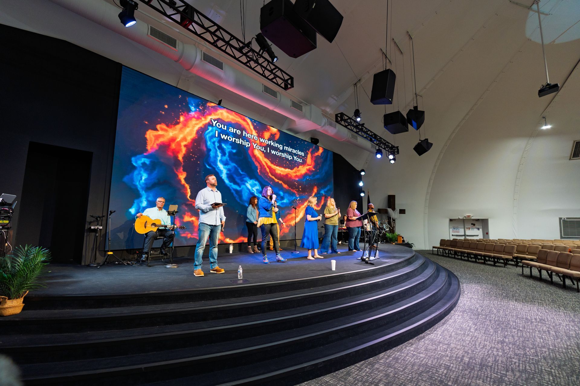 A man is playing an acoustic guitar in a band
