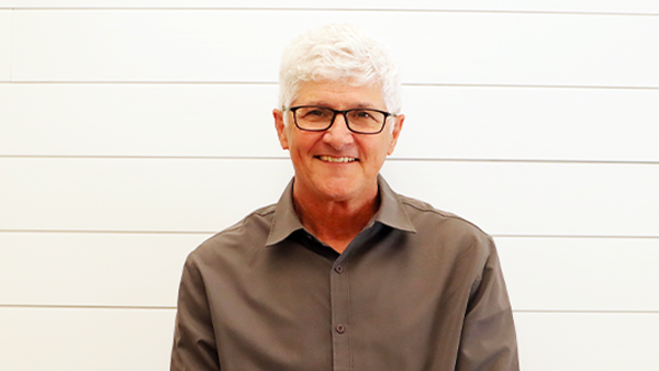 A man in a plaid shirt is smiling for the camera.