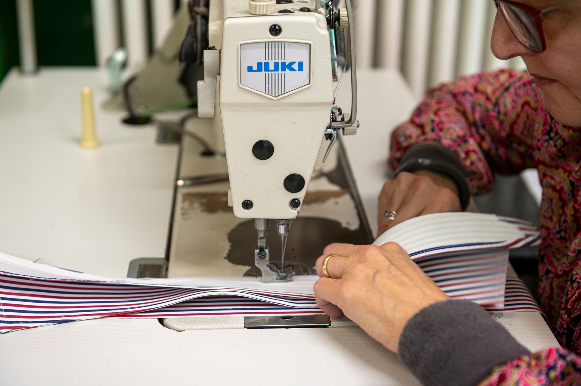 Una donna sta usando una macchina da cucire per cucire un pezzo di stoffa.