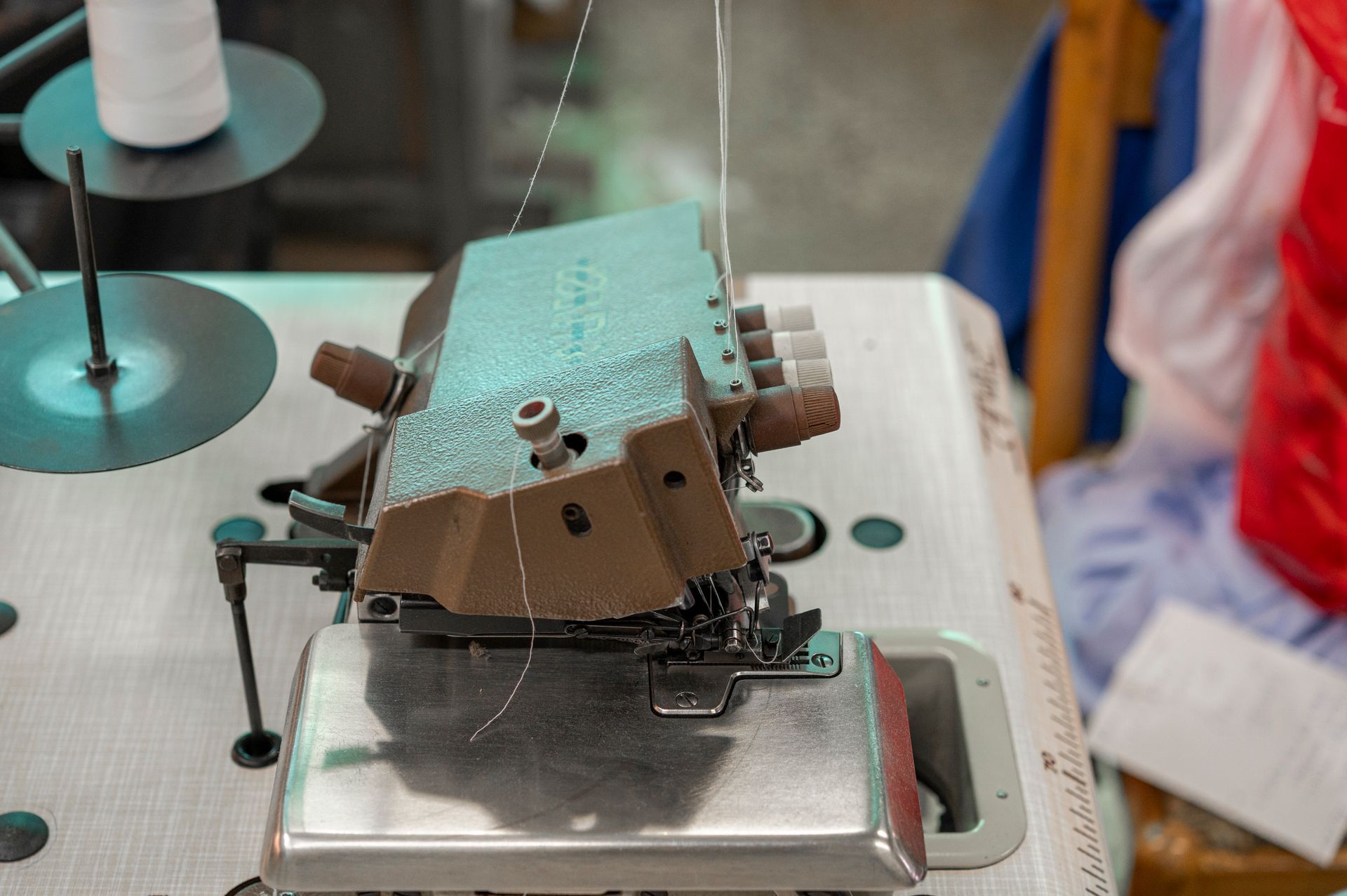 Una macchina da cucire è appoggiata su un tavolo in una fabbrica.