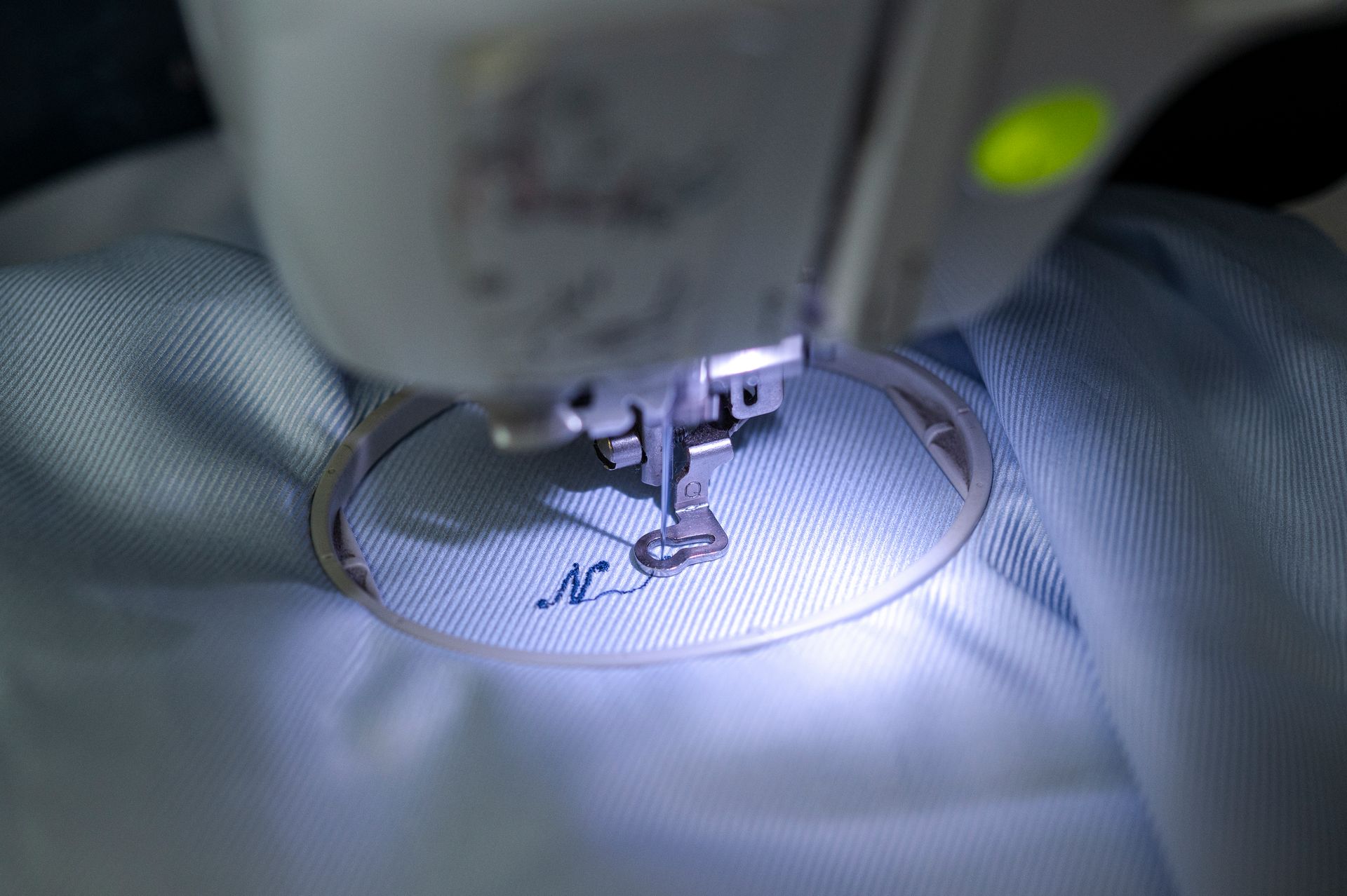 Primo piano di una macchina da cucire che cuce un pezzo di tessuto.