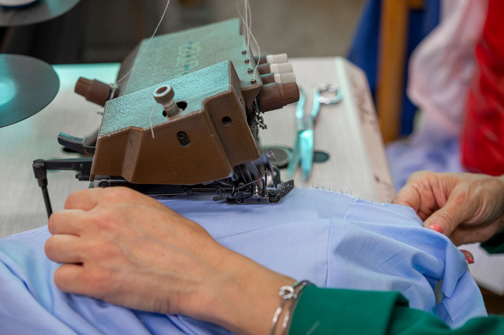 Una persona sta usando una macchina da cucire per cucire una maglietta.