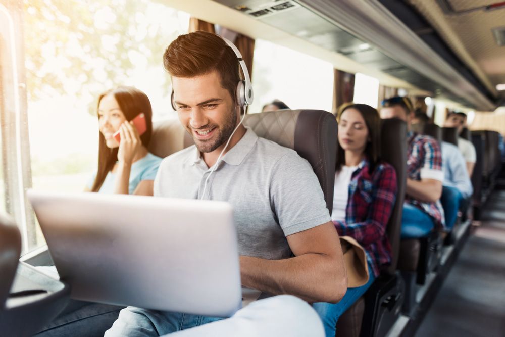 Guy On A Bus Working On His Laptop — TJ & B Bus and Coach Pty Ltd In South Murwillumbah, NSW