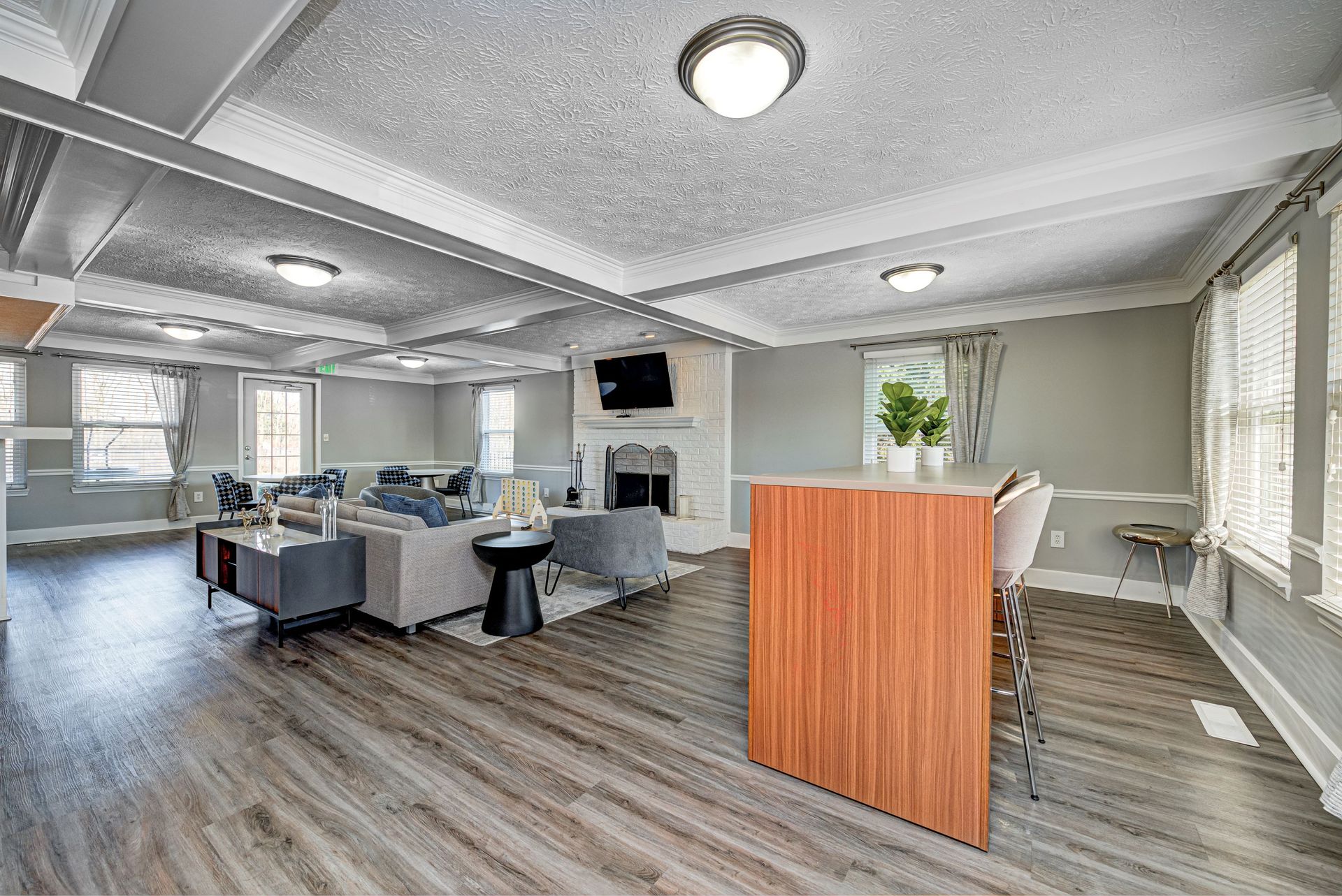 A room with hardwood floors , a fireplace , a table and chairs.