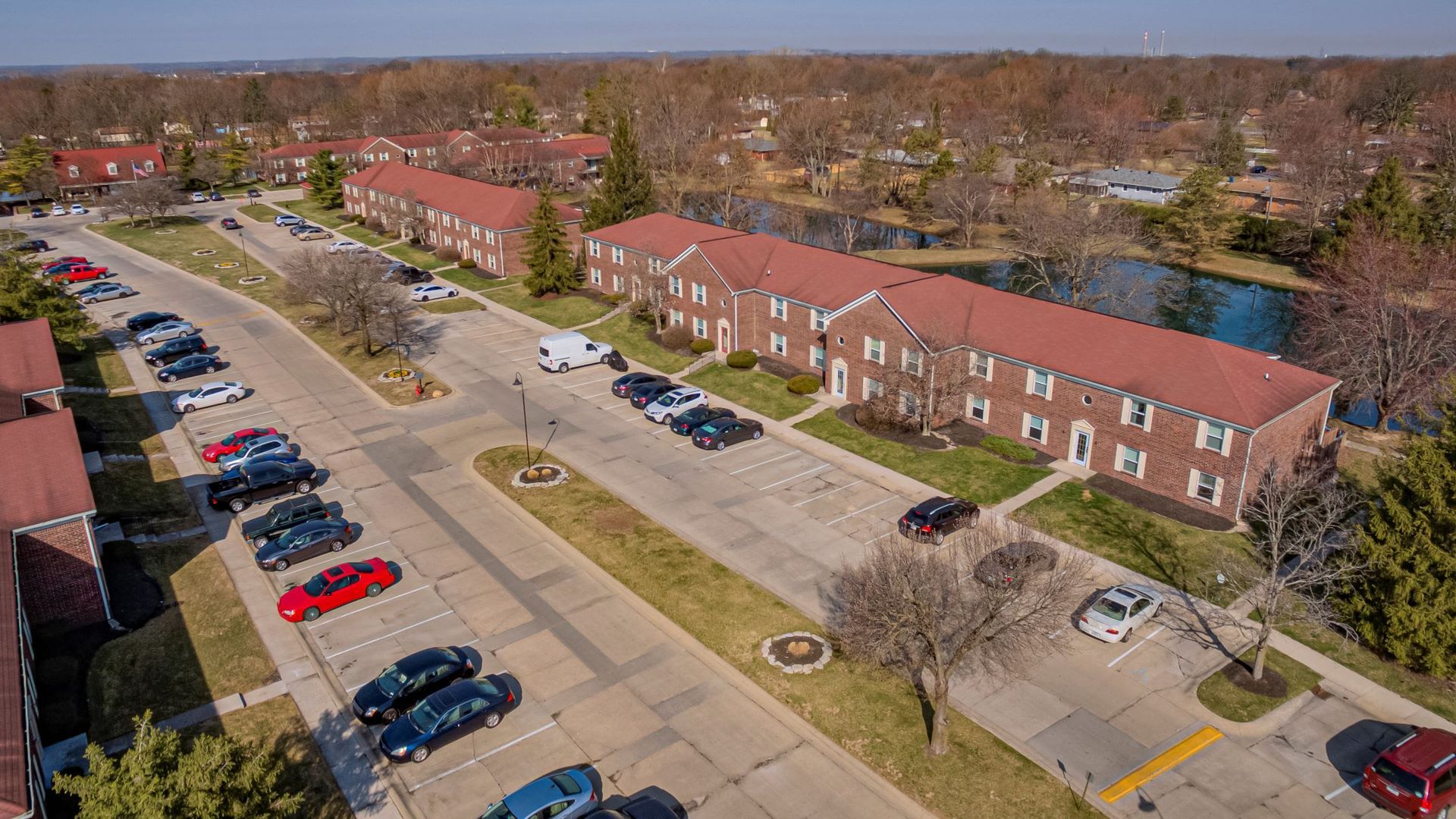 An aerial view of a residential area with a lot of cars parked in front of buildings.