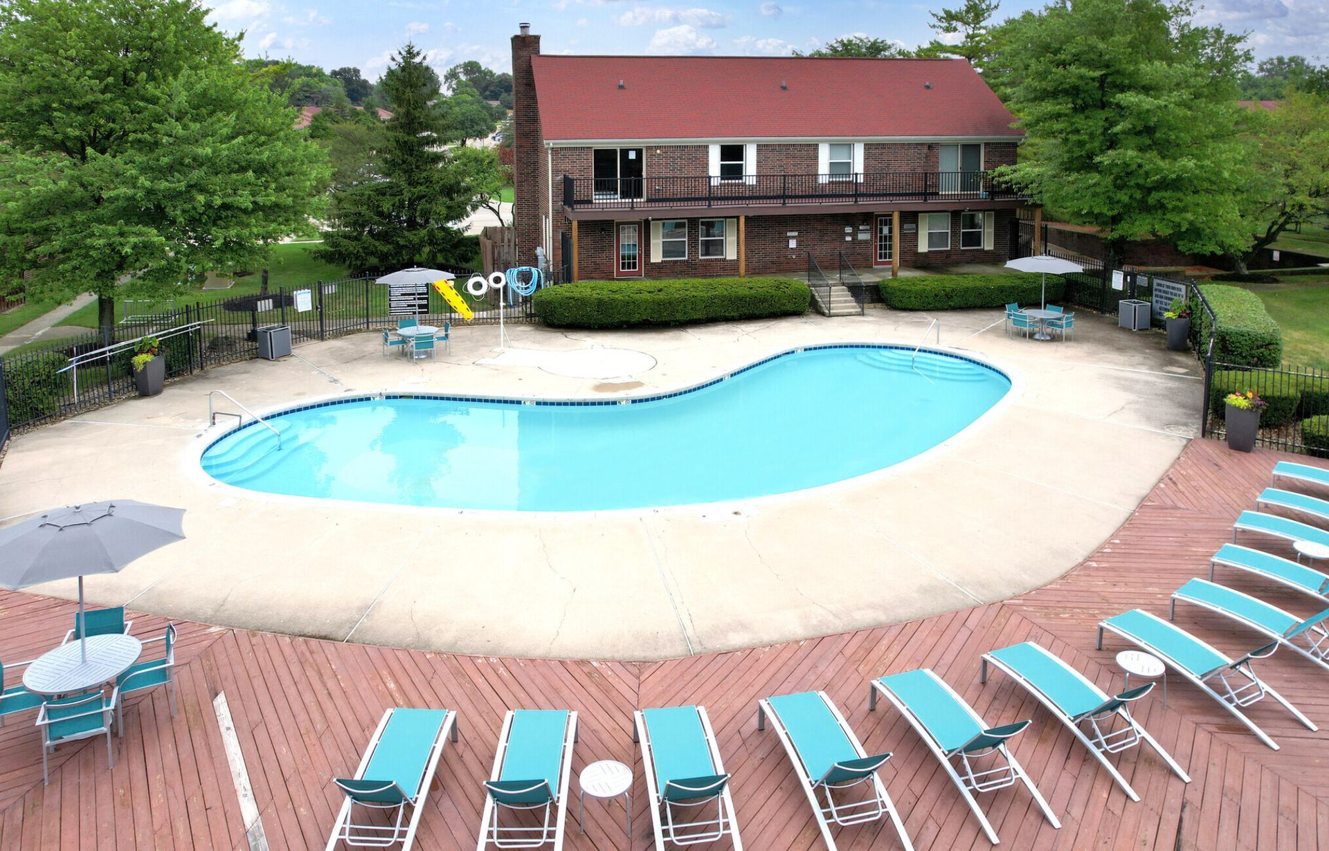 An aerial view of a large swimming pool surrounded by chairs and umbrellas.
