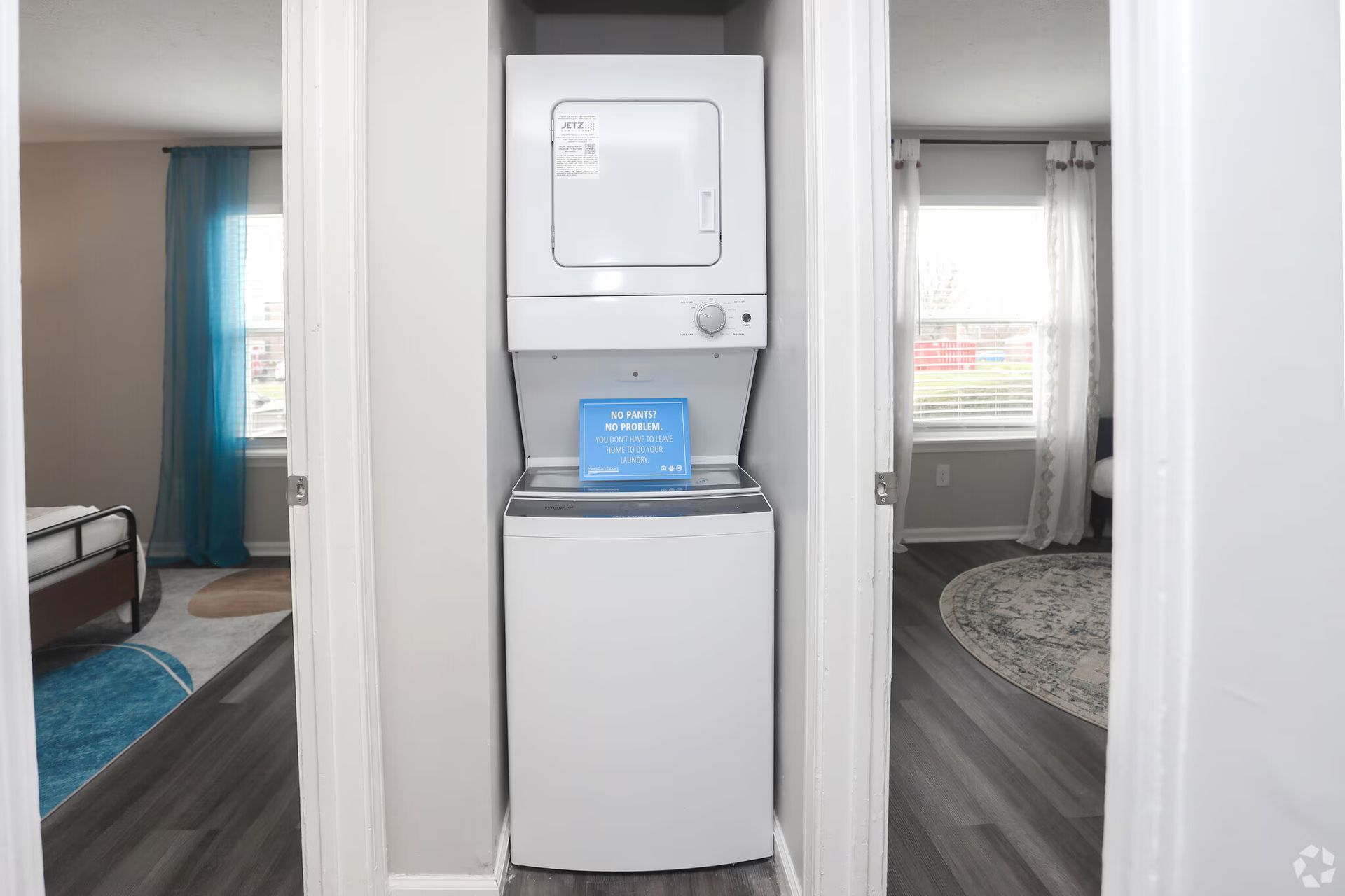 A washer and dryer are stacked on top of each other in a closet.