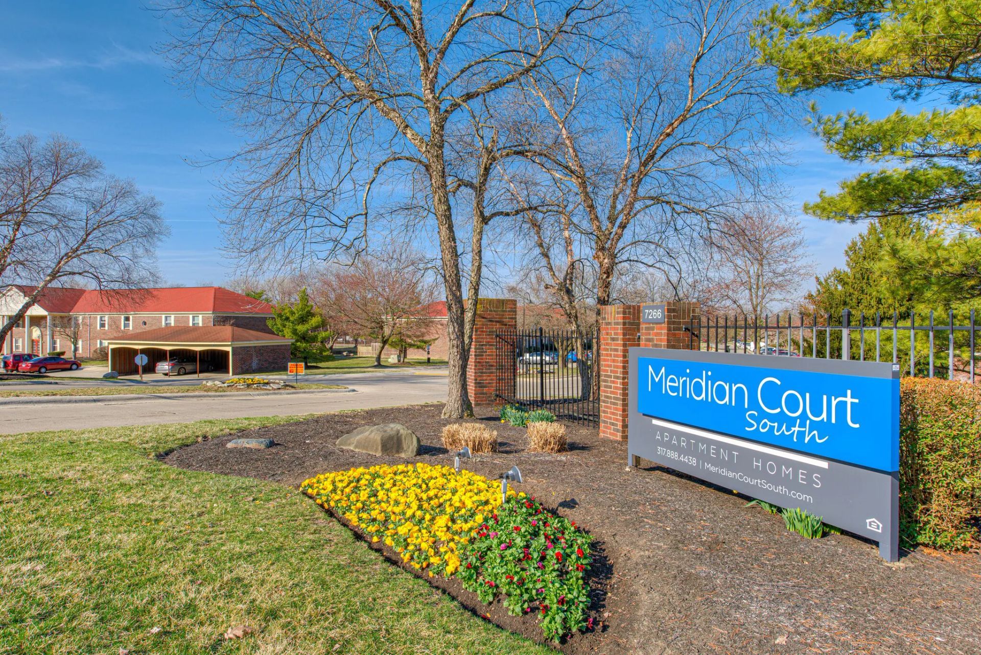 A blue sign that says ' meridian court ' on it is in front of a building.