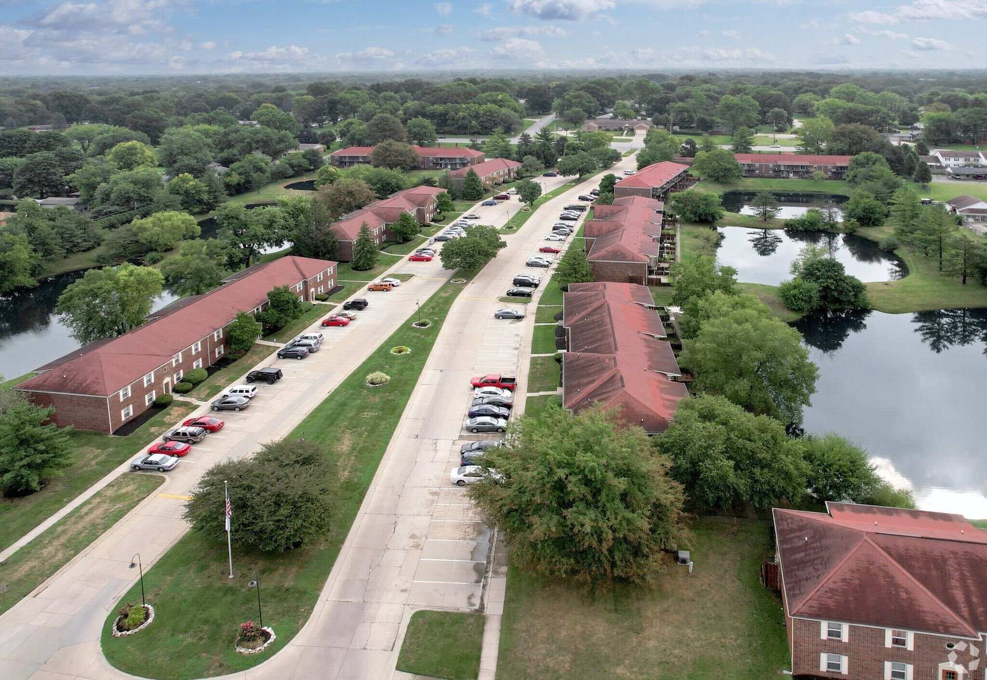 An aerial view of a residential area with a lake in the middle.
